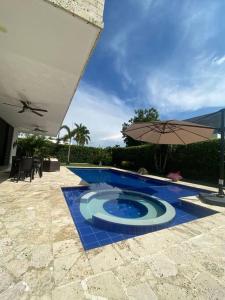吉拉尔多特Hermosa casa de campo con piscina Girardot flandes的露台旁的游泳池及其遮阳伞