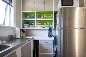 陶波Turangi Home Family Size的厨房配有不锈钢冰箱和绿色架子