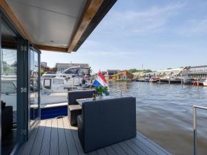 厄伊特海斯特Tiny houseboat Uitgeest I的船上配有桌椅的码头