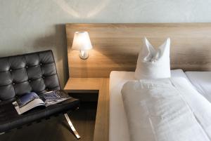 弗利姆斯阿尔卑斯山酒店的一间卧室配有一张床和一把带枕头的椅子