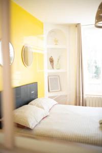 南希MLA Homes - Sunny Foller的一间卧室设有一张黄色墙壁和窗户的床