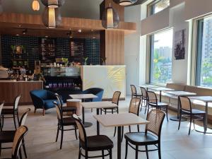 塔穆宁Guam Plaza Resort的一间带桌椅的餐厅和一间酒吧