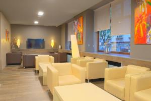 庞特维德拉巴哈斯海岸酒店的一间设有黄色椅子和电视的等候室
