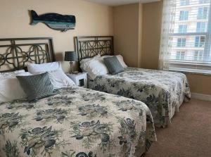 德通纳海滩海岸Opus Condominiums的一间卧室设有两张床,墙上有一条鱼