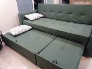 哥打京那巴鲁Qilala DualView by The Shore的绿色沙发,上面有两个枕头