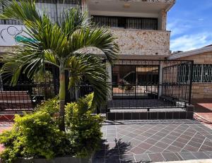 麦德林Casa Indigo Laureles-Estadio con Jacuzzi的黑栅栏前的棕榈树