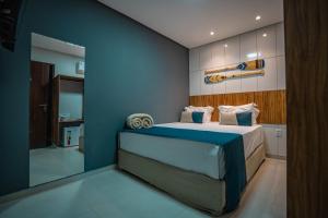 马拉戈日Pousada Antonella的一间卧室配有一张蓝色墙壁的床