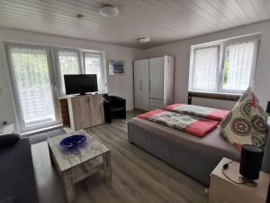 库克斯港Pension Haus Erika的一间卧室设有一张床、一台电视和窗户。