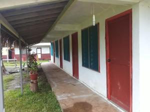 卢甘维尔Kathy B Guesthouse的一条带有红色和绿色门的建筑走廊