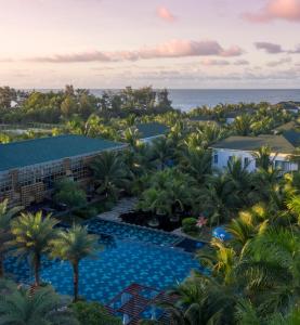 后川Le Palmier Ho Tram Resort的享有带游泳池和海洋的度假村的空中景致