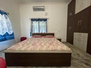 德奥加尔Parmarth Lok的一间卧室配有一张床、一个梳妆台和一扇窗户。