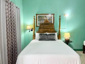 尼格瑞尔Summerset Residence Negril的一间卧室配有一张带白色床罩的床