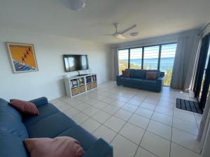 天阁露玛Bayview Breeze的客厅配有蓝色的沙发和电视