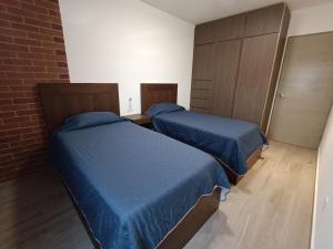 蒙特雷Departamento nuevo en Centro Cuauhtémoc的小客房内的两张床,配有蓝色的床单