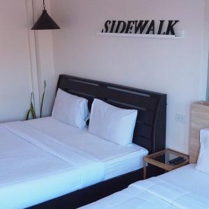 沙美岛Sidewalk Boutique Hotel的客房内的两张床和白色枕头