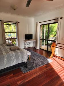 MooloolahBrom Cottage的一间卧室设有床和滑动玻璃门