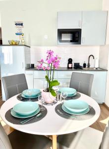 下厄尔什AZUR Panoráma Apartman的白色的厨房,配有白色的桌子和蓝色的盘子
