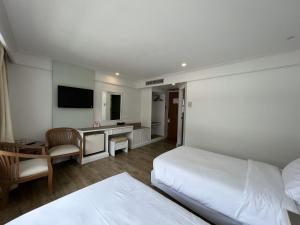 南府黛瓦拉奇酒店的酒店客房设有两张床、一张桌子和一台电视。
