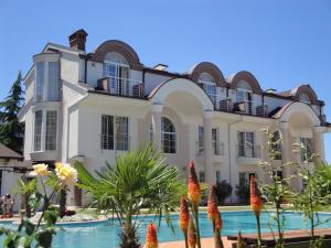 奥赫里德亚历山大别墅及水疗酒店的一座大房子,前面设有一个游泳池