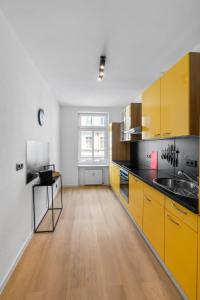 莱比锡Levax Living - 61 qm - Cozy - close to the city的厨房设有黄色橱柜和木地板