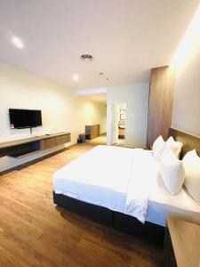 吉隆坡Imperial Regency Suites & Hotel Petaling Jaya的卧室配有一张白色大床和一台平面电视。