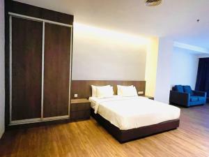 吉隆坡Imperial Regency Suites & Hotel Petaling Jaya的一间卧室设有一张床和一个滑动玻璃门