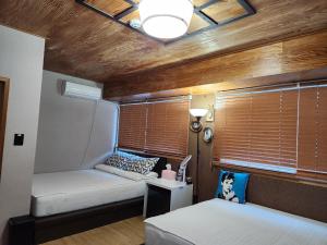 木浦市Leehakjang guesthouse的一间小卧室,配有两张床和窗户