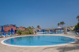 梅罗那瑞斯Meloneras Suites的度假村内的大型游泳池,配有椅子