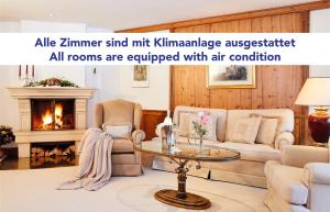 滨湖采尔Salzburgerhof, das 5-Sterne Hotel von Zell am See的客厅配有沙发、椅子和壁炉