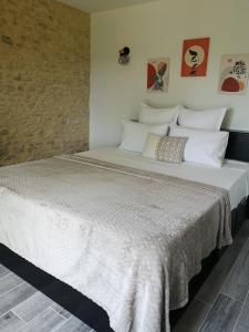 蒙蒂尼亚克Domaine de Lascaux的一张配有白色床单和壁画的大床