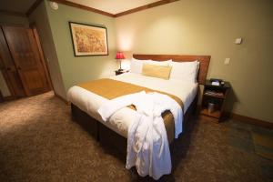南太浩湖Avalon Lodge South Lake Tahoe的一间卧室配有一张大床,上面有连衣裙