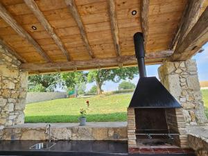 Villa & Spa Luxuria的一个带户外烤箱的木制屋顶户外厨房