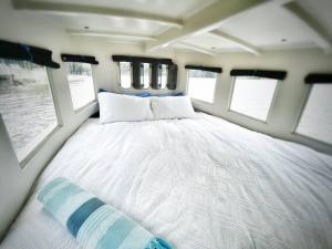 爱德华港Baby Blue Houseboat的一张大床,位于带窗户的房间中间