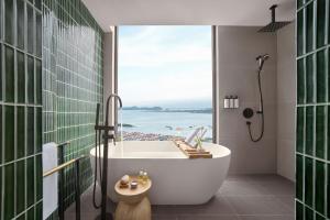 下龙湾The Yacht Hotel by DC的带浴缸的浴室,享有海景