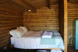 CorscombeKnapp Farm Glamping Lodge 2的小木屋内一间卧室,配有一张床