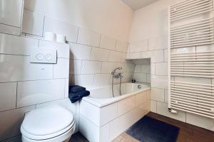 施塔德Der Stader Hafenblick的白色的浴室设有卫生间和浴缸。