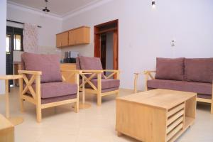 姆巴拉拉The Junction Apartments的客厅配有紫色椅子和茶几