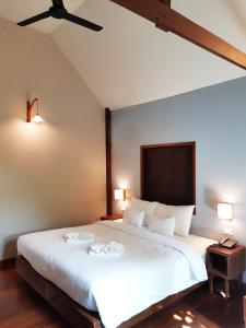 清莱PAN KLED VILLA eco hill resort - SHA extra plus的卧室配有一张白色大床和吊扇