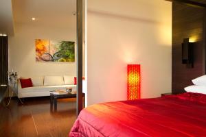 孟买瑞典设计型酒店的酒店客房配有红色的床和沙发