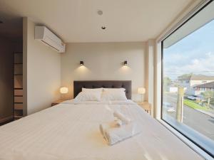 奥克兰Takapuna Brand new 3 Bedrooms的一间卧室设有一张大床和一个大窗户