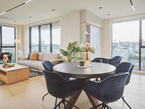 奥克兰Takapuna Brand new 3 Bedrooms的客厅配有桌椅