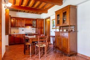 马萨马里蒂马Casa Vacanza Il Carpignone 6的厨房配有木制橱柜和木桌及椅子