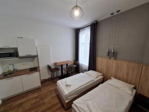 汉诺威Aparthotel Lenau的带两张床的房间和带桌子的厨房