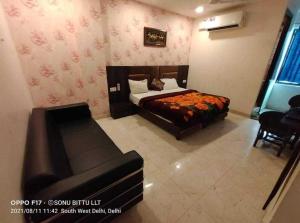新德里OYO Hotel Shivam In的一间卧室配有一张床和一张沙发
