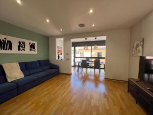 略夫雷加特河畔圣费柳CASA NEUS, casa junto a Barcelona的一间带蓝色沙发的客厅和一间用餐室