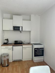 盖布利茨Gästehaus Barbara的厨房配有白色橱柜和炉灶。