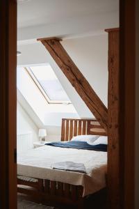 SlavēkaKroņakrogs的一间卧室配有一张木床和天窗