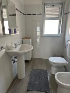 NunziataNunziata Apartment的白色的浴室设有水槽和卫生间。