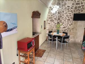奥里亚Il nido delle aquile的厨房配有桌子和红色微波炉