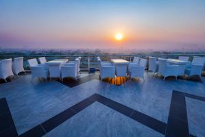 曼德勒Havana Hotel Mandalay的日落时分带桌椅的阳台